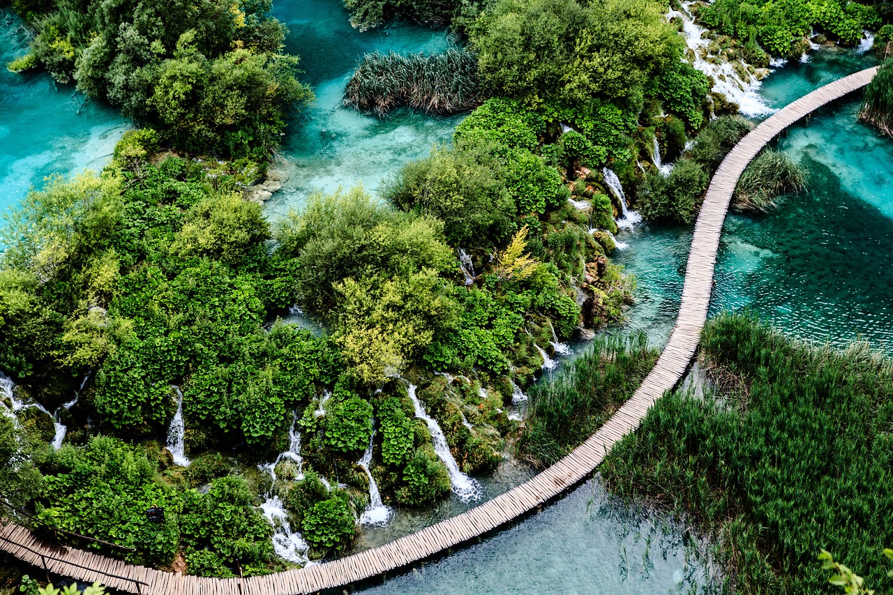 Foto com um caminho entre as cachoeiras e lago do Parque Nacional dos Lagos de Plitvice, na Croácia, país com programa de visto para nômades digitais.